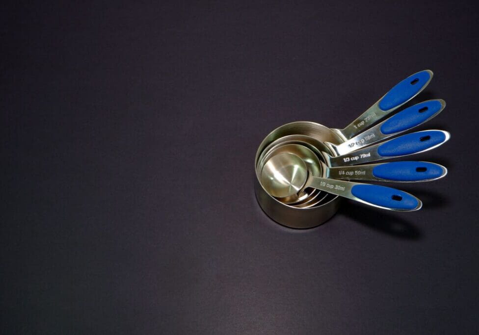 Measuring cups laying together on black background close up view