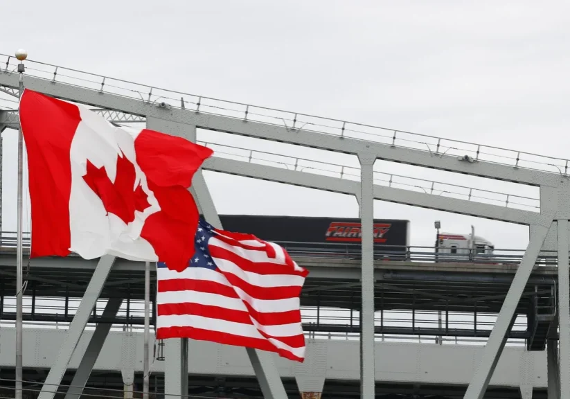 Canadian and US flags on bridge.