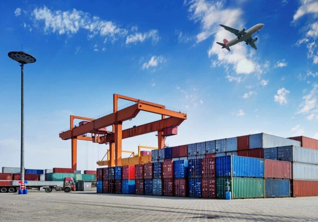 Cargo port with airplane overhead.